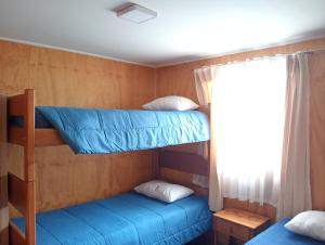 two bunk beds in a room with a window at Cabaña Río Blanco in Curacautín