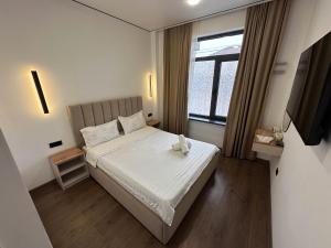 a small bedroom with a bed and a window at Gatsby Djal in Bishkek