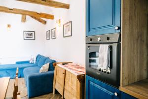 a living room with a blue couch and an oven at Demeter Guesthouse WOLF Siklod in Şiclod +64 photos