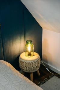 a small table with a lamp on it next to a bed at Demeter Guesthouse WOLF Siklod in Şiclod