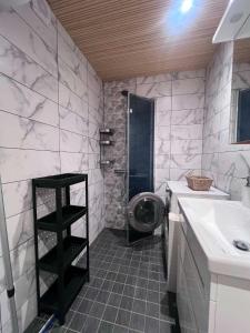 a bathroom with a sink and a washing machine at Viskoosa Näkmani Apartment in Kõrgessaare