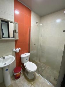 a bathroom with a toilet and a glass shower at Hotel Nella Mar in Puerto Colombia