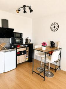 a living room with a table and a kitchen at Apprt la teste de buch in La Teste-de-Buch