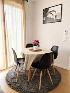 a dining room table with chairs and a vase of flowers on it at Apprt la teste de buch in La Teste-de-Buch +3 photos