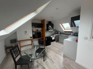a small kitchen with a glass table in a room at One Bed Flat Close to Station & River in Reading +3 photos