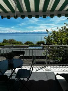 a patio with a table and chairs and a view of the water at Kling am See in Friedrichshafen