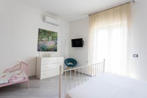 a white bedroom with a bed and a dresser at Victoria House Pompei in SantʼAntonio Abate