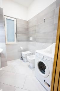 a bathroom with a washing machine and a toilet at Victoria House Pompei in SantʼAntonio Abate