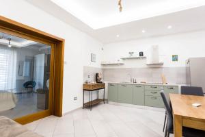 a kitchen with green cabinets and a table and a dining room at Victoria House Pompei in SantʼAntonio Abate +16 photos