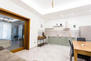 a kitchen and dining room with a table and a couch at Victoria House Pompei in SantʼAntonio Abate