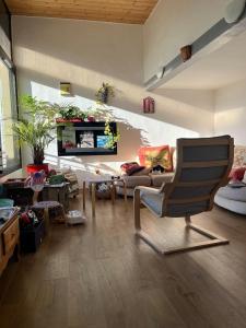 a living room with a chair and a couch at L'Hysope Gap, Maison d'hôtes contemporaine avec vue in Gap