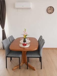 a wooden table with two chairs and a table with a plate of food at Apartma PERIN in Dobrovo