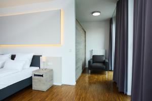 ein Schlafzimmer mit einem Bett und einem Stuhl in der Unterkunft Hella Globe in Lippstadt + 11 Fotos