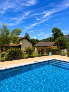 a swimming pool in front of a house at Complejo Turístico Les Cotolles in Cangas de Onís