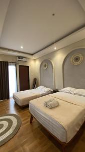a hotel room with two beds at Defano Villa Klotok in Yogyakarta +27 photos