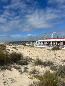 a beach with a building on the sand at Tavira Central Harmony in Tavira