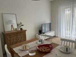 a living room with a table and a television at Tavira Central Harmony in Tavira