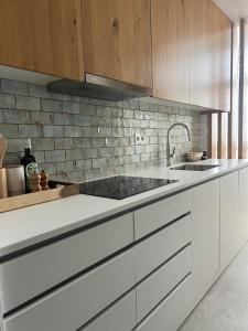 a kitchen with white cabinets and a sink at Tavira Central Harmony in Tavira