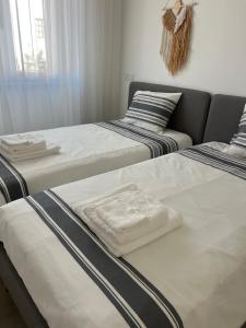 a room with three beds and a couch at Tavira Central Harmony in Tavira