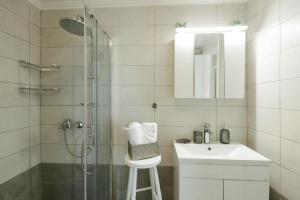 a bathroom with a shower and a sink and a mirror at Stella's Apartment in Karfas +26 photos