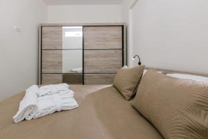 a bed with a pile of white towels on it at Stella's Apartment in Karfas
