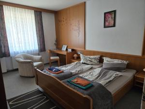 a bedroom with a bed and a chair in it at Biker Hotel Harmonie in Bad Grund