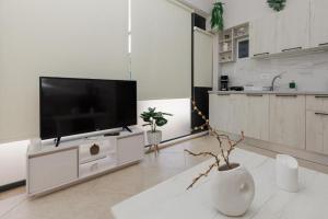 a living room with a flat screen tv on a cabinet at Stella's Apartment in Karfas