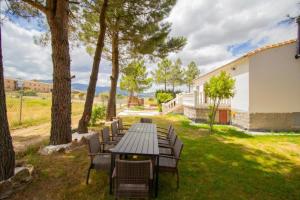 a picnic table and chairs in a yard with trees at La Casa del Alcalde in Ceguilla