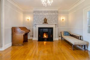 a living room with a piano and a fireplace at Historic 6-Bed Manor near Shifnal, Parking in Shifnal