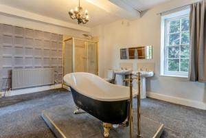 a bathroom with a large tub and two sinks at Historic 6-Bed Manor near Shifnal, Parking in Shifnal