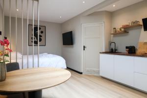 a bedroom with a bed and a table and a kitchen at City Suite Sneek in Sneek