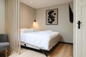 a bedroom with a bed and a chair at City Suite Sneek in Sneek