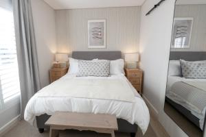 a bedroom with a large bed and a mirror at Sout Huijs Langebaan with hot tub in Langebaan