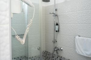 a shower with a glass door in a bathroom at Hotel Riviera Dhermi in Dhërmi