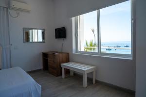 a bedroom with a bed and a window and a bench at Hotel Riviera Dhermi in Dhërmi