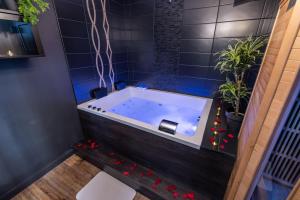a bathtub in a bathroom with blue tiles at Urban Spa Romantique Chic in Troyes +20 photos