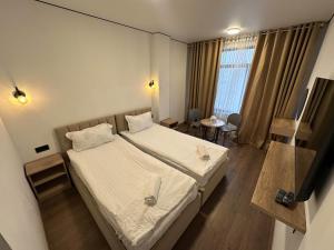 a hotel room with a bed and a television at Тихий Замок Джал in Bishkek