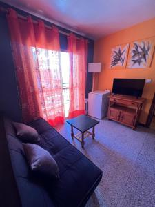 a living room with a couch and a television at Pensión El Alamo in Lepe +208 photos