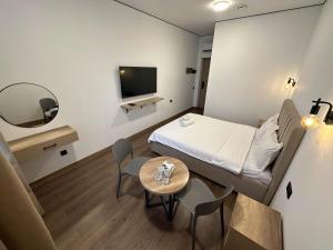 a small room with a bed and a table at Тихий Замок Джал in Bishkek