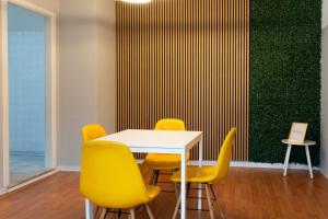 a table with yellow chairs and a green wall at Central Viale in Telese
