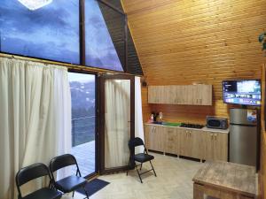 a kitchen with a table and chairs and a large window at Roinis Villa in T'khilnari
