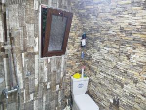 a bathroom with a toilet and a stone wall at Roinis Villa in T'khilnari