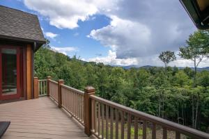 a wooden deck with a view of the mountains at Ridgeline Cabin in Elk Park