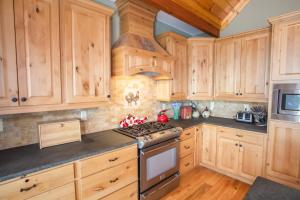 a kitchen with wooden cabinets and a stove top oven at Ridgeline Cabin in Elk Park