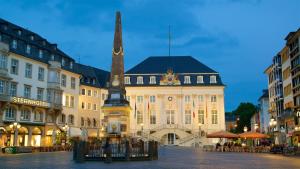 a building with a clock tower in the middle of a street at Downtown Apartment in Bonn