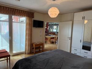 a bedroom with a bed and a dining room at Kleine Weite-Das Schwedenhus in Landesbergen