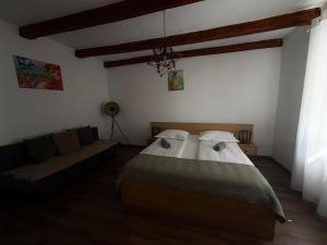 a bedroom with a bed and a couch at Apartament Turnul Olarilor in Sibiu