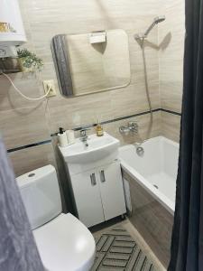 a bathroom with a toilet and a sink and a tub at Comfort VV in Volodymyr-Volynskyi