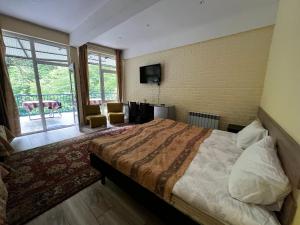 a bedroom with a large bed and a balcony at Riviera Guesthouse in Dilijan