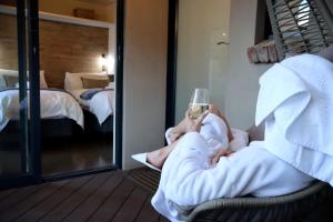 a man sitting in a chair with a glass of wine at Mon Cheri Clarens in Clarens +83 photos